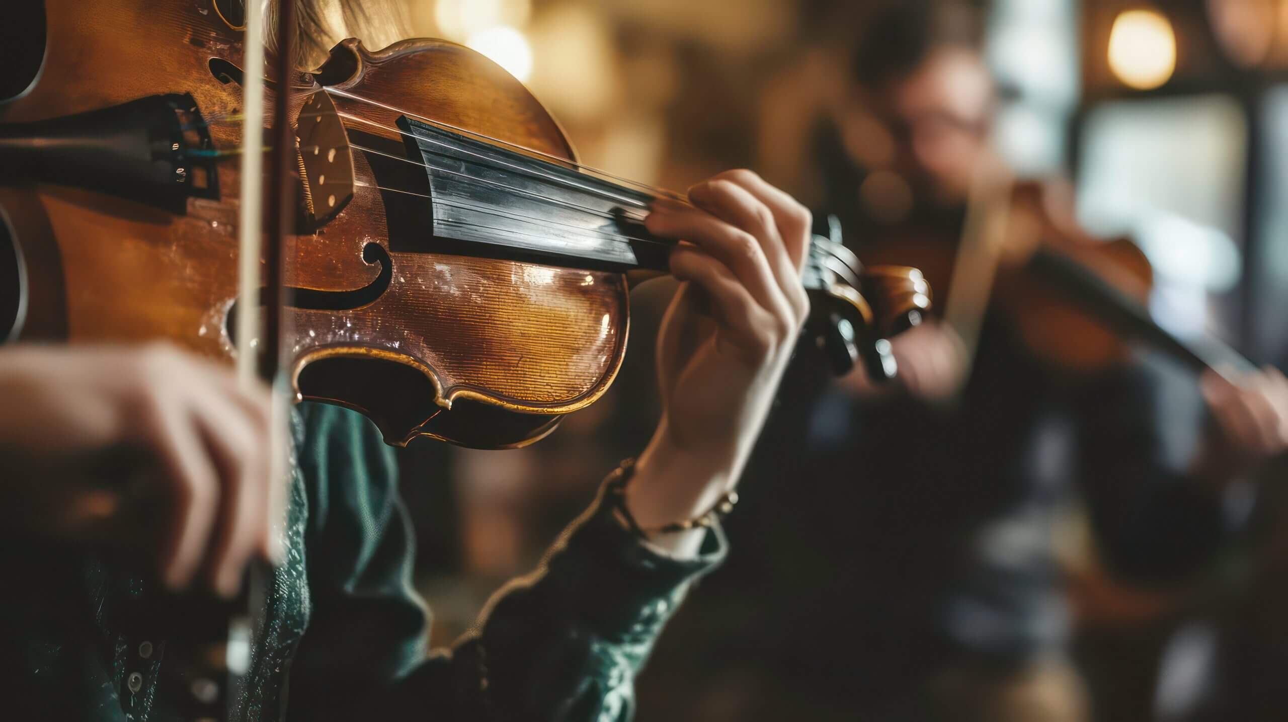 A close-up of a violinist's hands playing in a cozy setting.